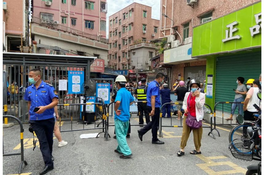 Guardias de seguridad en la entrada de la aldea urbana de Wanxia, que ha sido cerrada como parte de las medidas contra la COVID-19 en Shenzhen, provincia de Guangdong, China, el 29 de agosto de 2022. (David Kirton/Reuters)