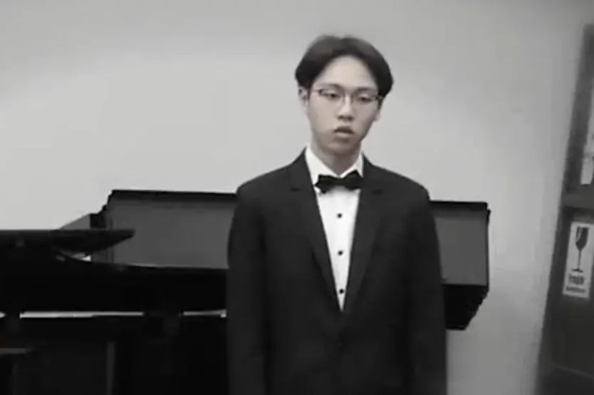 Yi-Chi canta frente a un piano. (Captura de pantalla del vídeo de The Epoch Times)