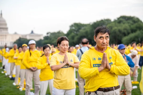 Los practicantes de Falun Dafa practican ejercicios antes de participar en una vigilia con velas en memoria de los practicantes que fueron perseguidos hasta la muerte por el Partido Comunista Chino en China, en Washington el 17 de julio de 2025. (Samira Bouaou/The Epoch Times)