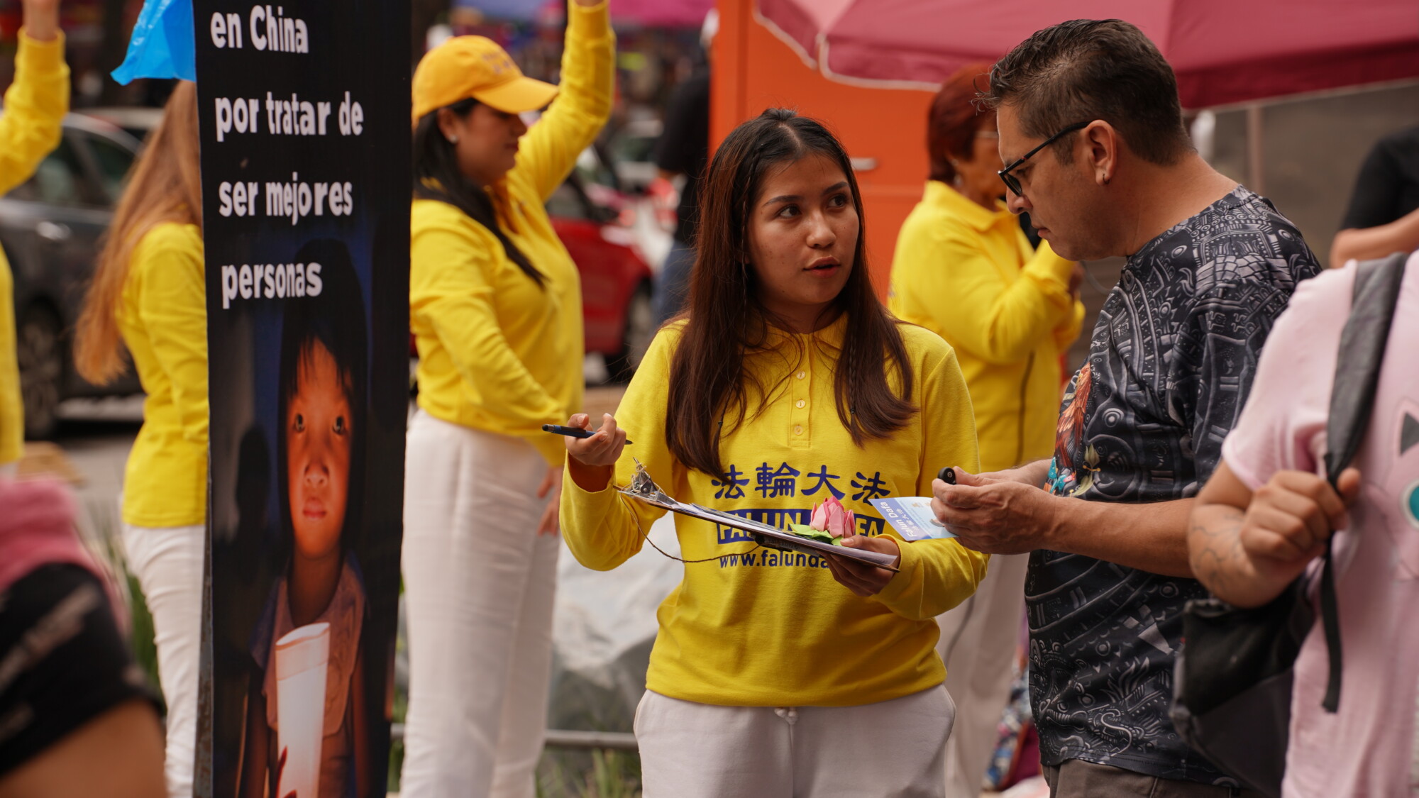 <em>Una manifestante de México habla sobre los beneficios de la disciplina Falun Dafa y su persecución por el PCCh a personas mientras otros manifestantes demuestran los ejercicios de relajación frente a la Alameda Central de la CDMX, México el 20 de julio de 2025. (The Epoch Times)</em>