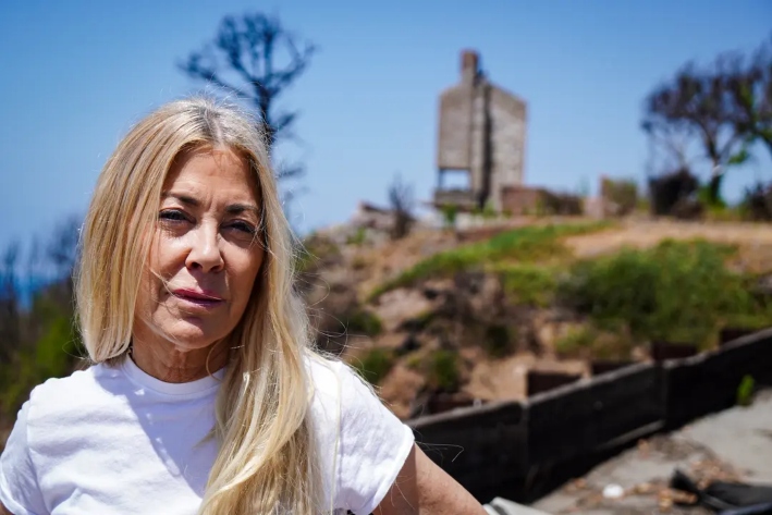 La promotora inmobiliaria de Pacific Palisades, Elaine Culotti, delante de una casa destruida el 3 de julio de 2025. La casa de Culotti, situada frente al mar, sufrió importantes daños en el incendio de Palisades. (Allan Stein/The Epoch Times)