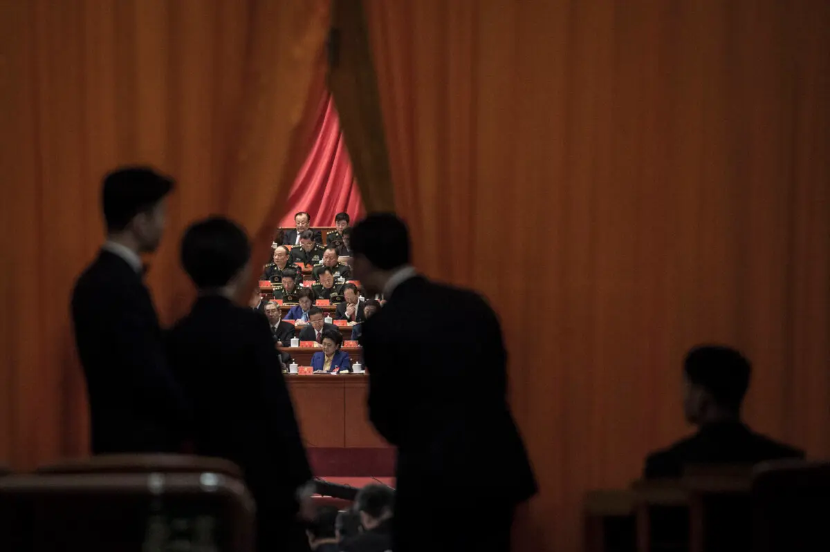 Guardias de seguridad chinos observan a los delegados militares durante el discurso del líder chino Xi Jinping en el XIX Congreso del Partido Comunista Chino en Beijing, el 18 de octubre de 2017. (Fred Dufour/AFP a través de Getty Images)