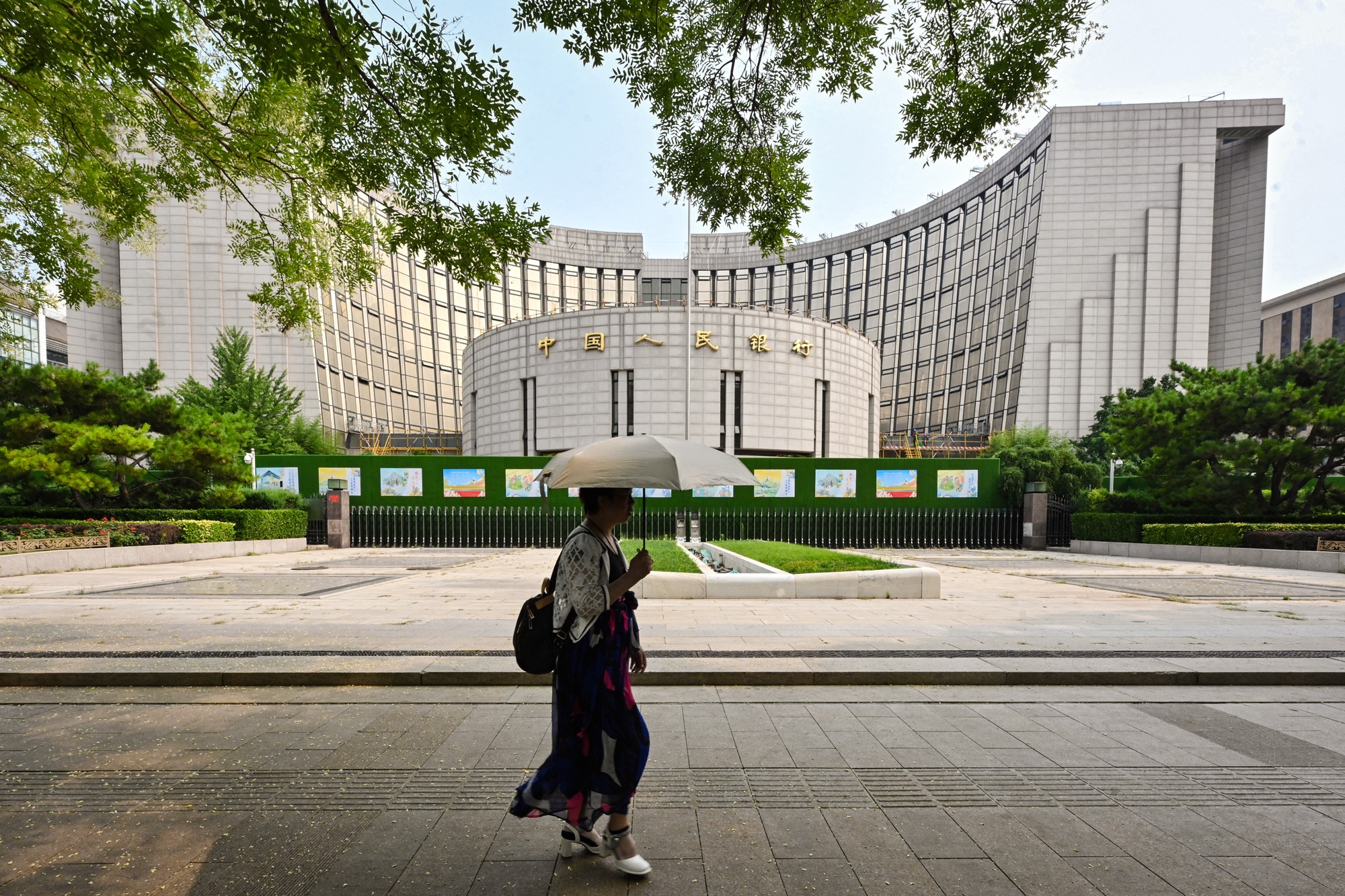 Una mujer pasa frente a la sede del Banco Popular de China en Pekín el 9 de julio de 2024. El banco central advirtió recientemente que los sistemas tradicionales de pagos transfronterizos corren el riesgo de ser "politizados" y "utilizados como arma" en medio de las crecientes tensiones geopolíticas. (Adek Berry/AFP a través de Getty Images).