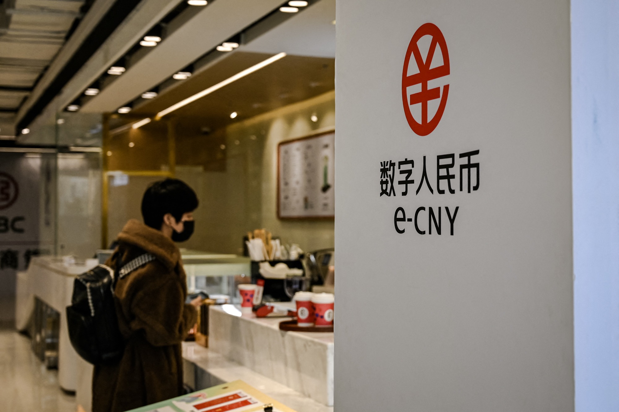 Se ve un cartel de la moneda digital china cerca de una cafetería en el New Actuation Fintech Center de Beijing el 17 de febrero de 2022. (Jade Gao/AFP a través de Getty Images).