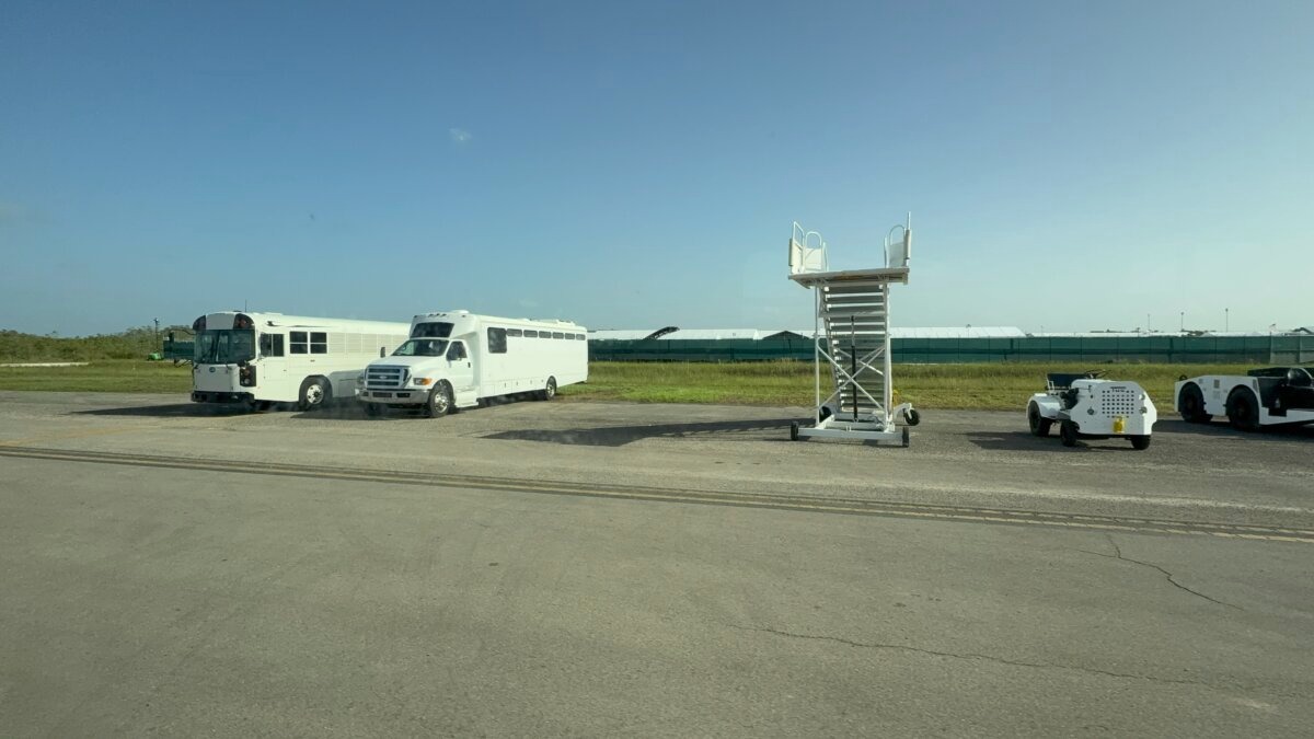 Autobuses de transporte y una escalera plegable para subir a los aviones se encuentran frente a las instalaciones de Alligator Alcatraz en el condado de Collier, Florida, el 25 de julio de 2025. (T.J. Muscaro/The Epoch Times).