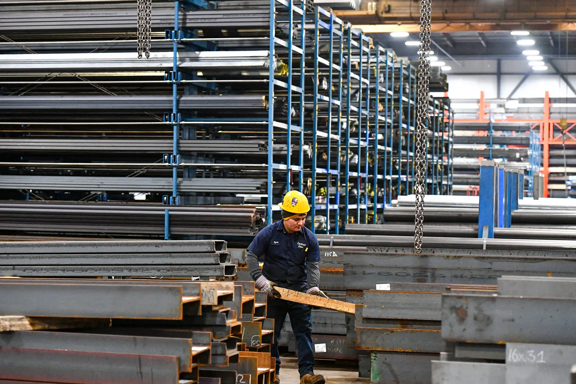 Un trabajador se prepara para levantar una viga de acero con una grúa en la Central Steel Supply Company en Marlborough, Massachusetts, el 13 de marzo de 2025. Estados Unidos importa alrededor de la mitad del acero y el aluminio que se utiliza en el país para fabricar artículos que van desde automóviles y aviones hasta latas de refrescos. (Joseph Prezioso/AFP a través de Getty Images)