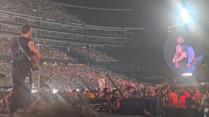 Chris Martin habla en el escenario sobre una pareja que aparece en la pantalla gigante durante un concierto de Coldplay en Foxborough, Massachusetts, el 16 de julio de 2025, en una imagen del vídeo. (@calebu2/TMX vía AP)