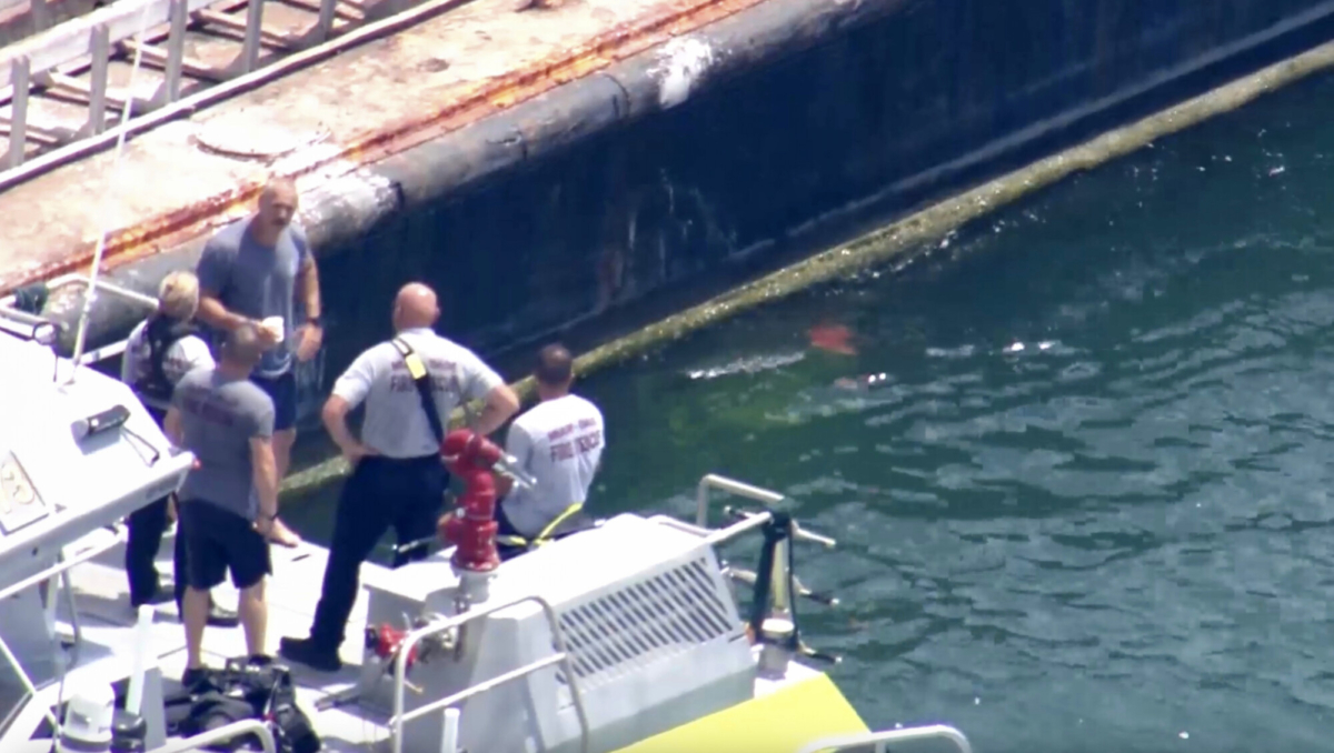 Esta imagen, tomada de un video proporcionado por WSVN-TV, muestra a personal del Departamento de Bomberos de Miami-Dade y otros en botes alrededor de lo que parece ser una barcaza involucrada en un accidente con un grupo de niños y un adulto en un velero durante un campamento de vela, el lunes 28 de julio de 2025, en Miami. (WSVN-TV vía AP)