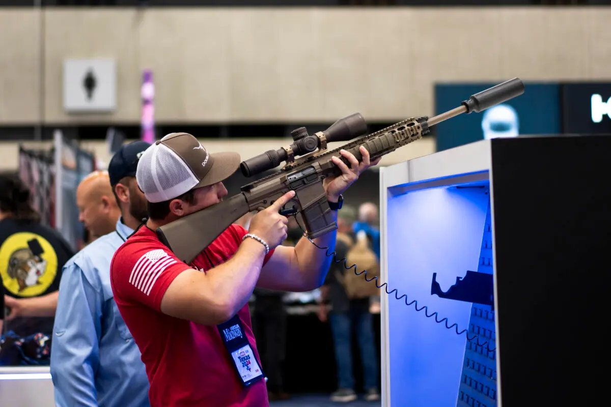 Personas prueban armas de fuego en la exposición de la Asociación Nacional del Rifle (NRA) en el Centro de Convenciones Kay Bailey Hutchison de Dallas, Texas, el 18 de mayo de 2024. (Madalina Vasiliu/The Epoch Times)
