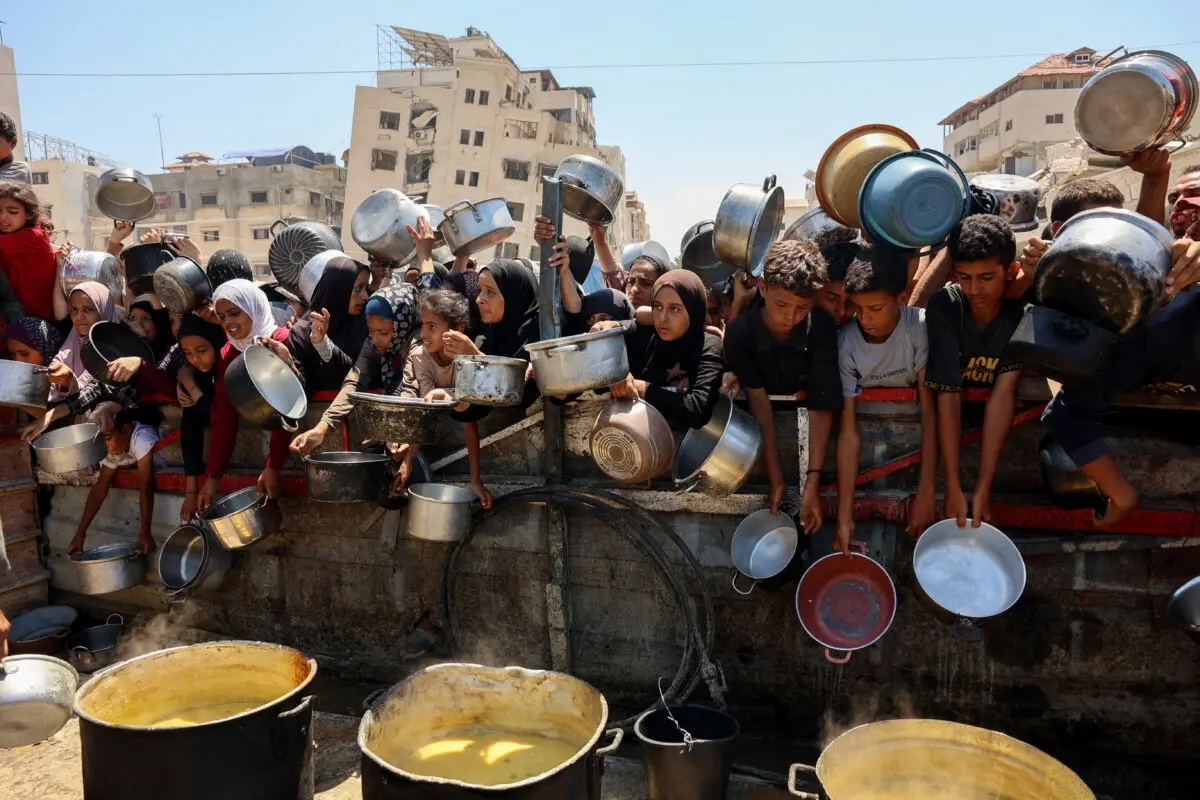 Palestinos reciben sopa de lentejas en un punto de distribución de alimentos en la ciudad de Gaza el 2 de agosto de 2025. (Omar Al-Qattaa/AFP a través de Getty Images)