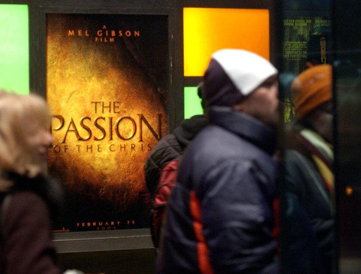 Los cinéfilos hacen cola frente a un anuncio de La pasión de Cristo, de Mel Gibson, en un cine de Nueva York, el 25 de febrero de 2004. (Stephen Chernin/Getty Images)