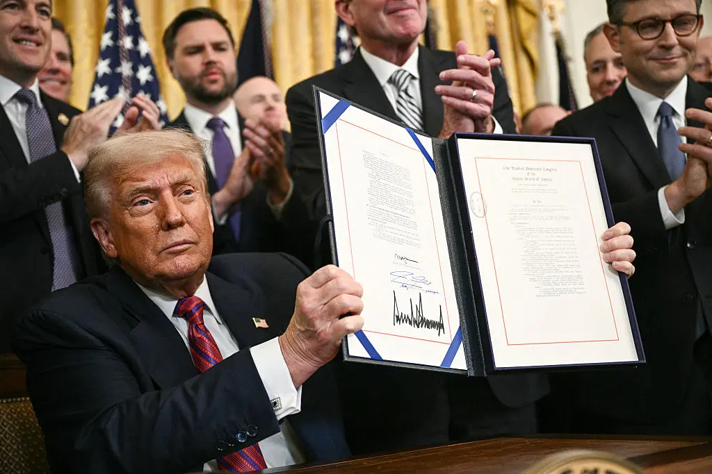 El presidente Donald Trump muestra la Ley GENIUS (Ley de Orientación y Establecimiento de la Innovación Nacional para las Monedas Estables de EE. UU.), que codifica el uso de las monedas estables tras su firma en el Salón Este de la Casa Blanca en Washington D. C., el 18 de julio de 2025. (Foto de BRENDAN SMIALOWSKI/AFP a través de Getty Images)