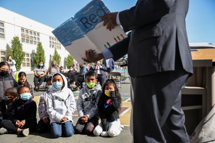El superintendente de escuelas del estado de California, Tony Thurmond, lee “Red: A Crayon's Story” a alumnos de segundo grado en la escuela primaria Nystrom de Richmond, California, el 17 de mayo de 2022. Las clínicas de California, un estado considerado un refugio para la atención relacionada con los transgéneros, han anunciado recientemente cambios en los tratamientos para menores. (Justin Sullivan/Getty Images)