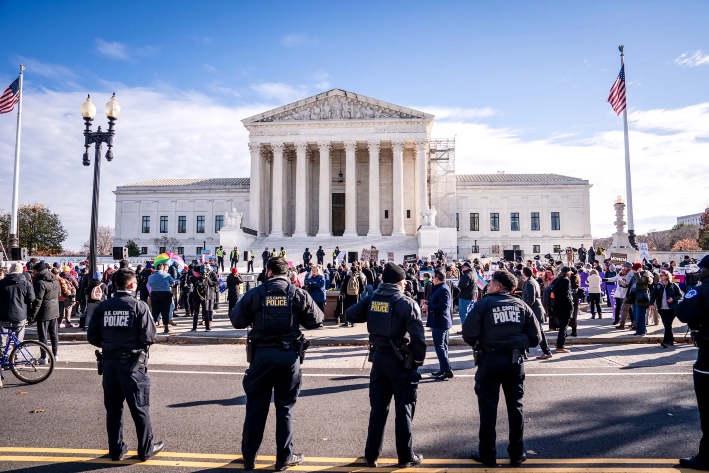 Agentes de la Policía del Capitolio de Estados Unidos permanecen en alerta mientras la gente protesta por un caso relacionado con la prohibición a los procedimientos relacionados con el género para menores, frente a la Corte Suprema en Washington, el 4 de diciembre de 2024. En junio, el alto tribunal confirmó una ley de Tennessee que prohíbe los bloqueadores de la pubertad y los tratamientos hormonales relacionados con la transexualidad para menores. (Madalina Vasiliu/The Epoch Times)