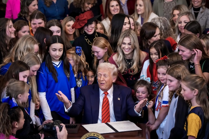 El presidente Donald Trump, acompañado por mujeres atletas, firma una orden ejecutiva que les prohíbe a los hombres que se identifican como mujeres transgénero competir en deportes femeninos, en la Casa Blanca, el 5 de febrero de 2025. Trump también firmó en enero una orden que prohíbe la financiación o la ayuda de Estados Unidos para tratamientos relacionados con la transexualidad y que hace cumplir las leyes que prohíben o restringen dichos procedimientos. (Andrew Harnik/Getty Images)