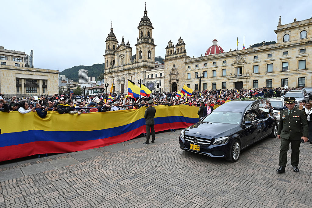 La gente se despide del coche fúnebre que transporta el ataúd con el cuerpo del candidato presidencial colombiano y senador Miguel Uribe tras una misa fúnebre celebrada en la Catedral Metropolitana de Bogotá el 13 de agosto de 2025. (LUIS ACOSTA/AFP a través de Getty Images)