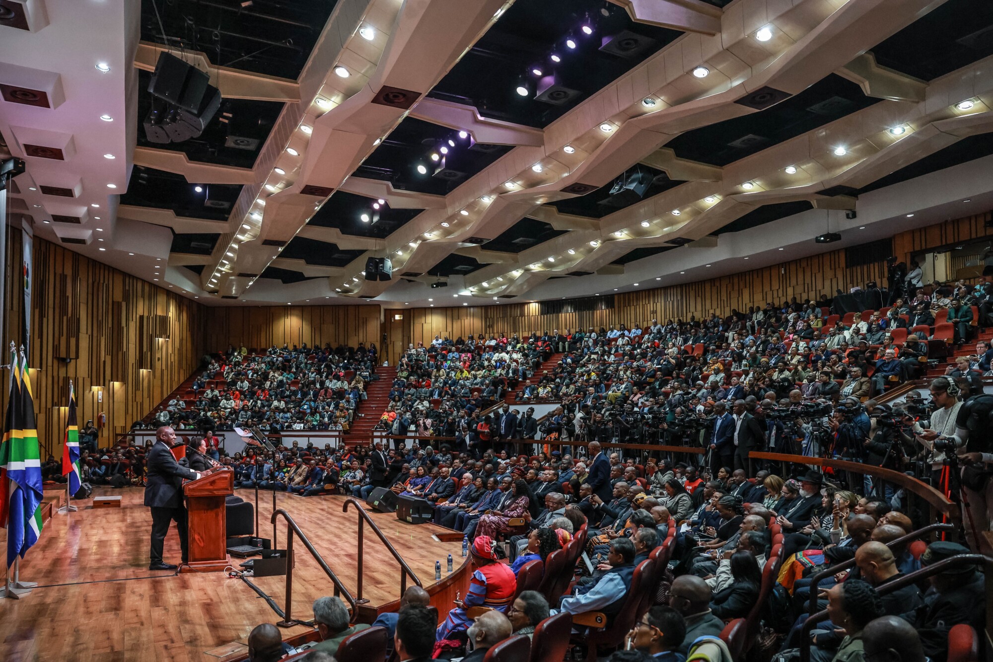 El presidente sudafricano Cyril Ramaphosa (izquierda) pronuncia su discurso durante la primera Convención Nacional celebrada en la Universidad de Sudáfrica, en Pretoria, el 15 de agosto de 2025. La convención marca el inicio de los debates nacionales en reuniones locales y plataformas públicas. (Phill Magakoe/AFP a través de Getty Images).