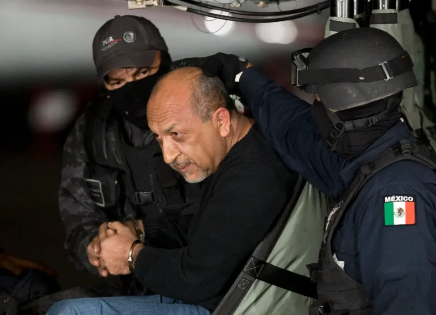 Policías federales mexicanos escoltan a Servando "La Tuta" Gómez, líder del cártel La Familia Michoacana, una de las 26 personas extraditadas el 12 de agosto de 2025, mientras se sienta dentro de un helicóptero en Ciudad de México, México, el 27 de febrero de 2015. (Eduardo Verdugo/AP Photo)