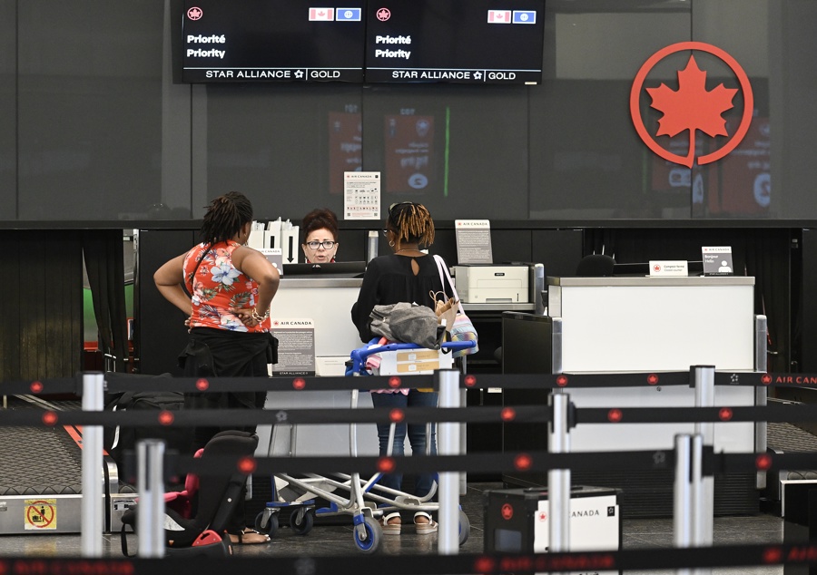 Un agente de Air Canada ayuda a los viajeros en el Aeropuerto Internacional Montreal-Trudeau, en Montreal, Canadá. (EFE/EPA/GRAHAM HUGHES)