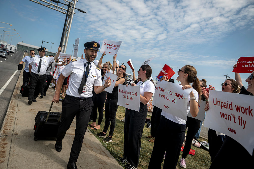 MONTREAL, CANADÁ - 16 DE AGOSTO: Pilotos muestran su apoyo a los auxiliares de vuelo de Air Canada que participan en una huelga general en el Aeropuerto Internacional Pierre Elliott Trudeau de Montreal el 16 de agosto de 2025 en Montreal, Canadá. Tras la huelga de más de 10,000 auxiliares de vuelo de Air Canada esta madrugada, la aerolínea más grande del país se vio obligada a suspender sus operaciones y cancelar sus 700 vuelos diarios. (Foto de Andrej Ivanov/Getty Images)