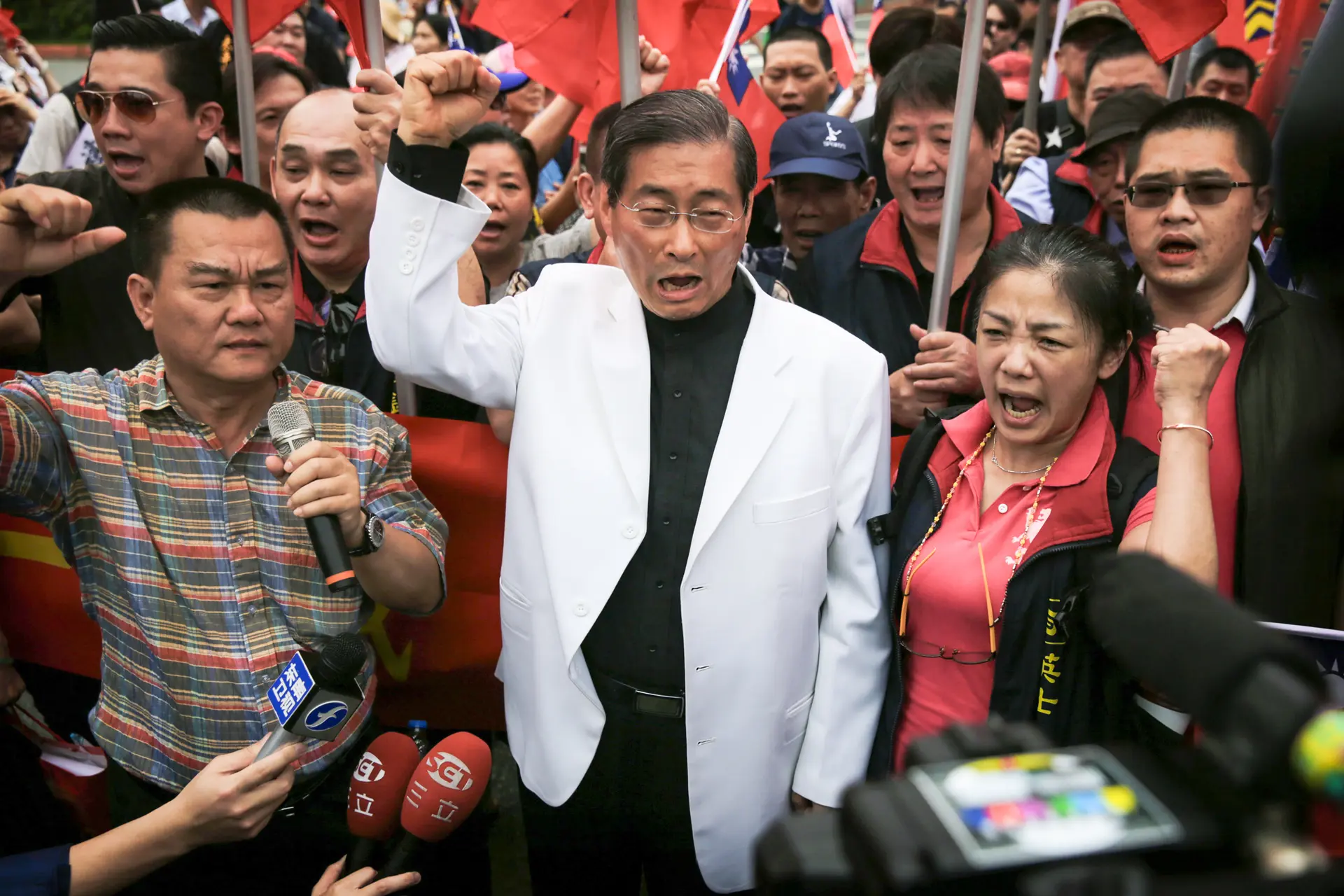 El jefe de la organización criminal Chang An-lo (C), líder del Partido para la Promoción de la Unificación de China, corea consignas con sus seguidores durante la toma de posesión de la presidenta taiwanesa Tsai Ing-wen en Taipéi, Taiwán, el 20 de mayo de 2016. En enero, el Ministerio del Interior de Taiwán solicitó a la Corte Constitucional la disolución del partido, alegando que actuaba a instancias del Partido Comunista Chino. (Isaac Lawrence/AFP a través de Getty Images).