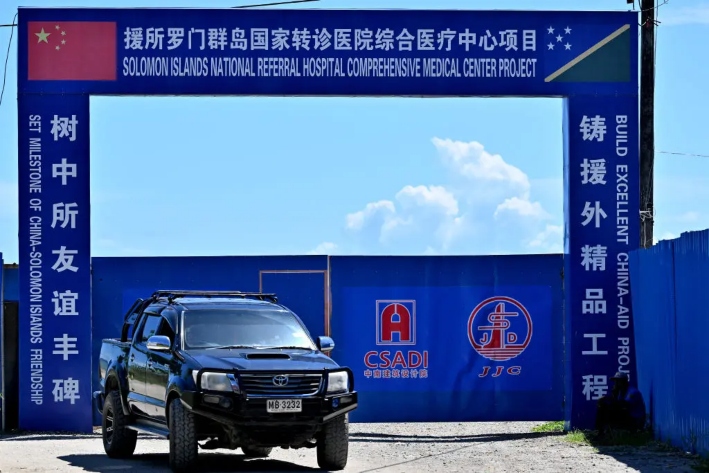 Esta fotografía, tomada el 21 de abril de 2024, muestra un automóvil pasando junto a un centro médico en construcción financiado por el régimen chino, en Honiara, capital de las Islas Salomón. (Saeed Khan/AFP vía Getty Images)