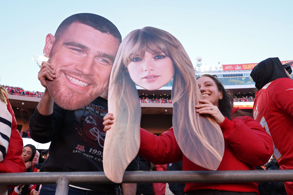 KANSAS CITY, MISURI - 10 DE NOVIEMBRE: Aficionados de los Kansas City Chiefs sostienen carteles de Travis Kelce #87, de los Kansas City Chiefs, y Taylor Swift en el último cuarto de un partido contra los Denver Broncos en el GEHA Field del Arrowhead Stadium el 10 de noviembre de 2024 en Kansas City, Misuri. (Foto de Jamie Squire/Getty Images)