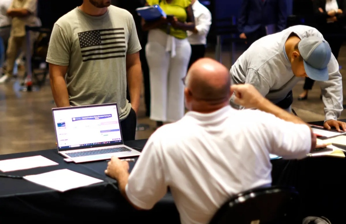 La gente habla con los reclutadores mientras el Servicio de Inmigración y Control de Aduanas de Estados Unidos (ICE) celebra un importante evento de contratación en Arlington, Texas, el 26 de agosto de 2025. (Ron Jenkins/Getty Images)