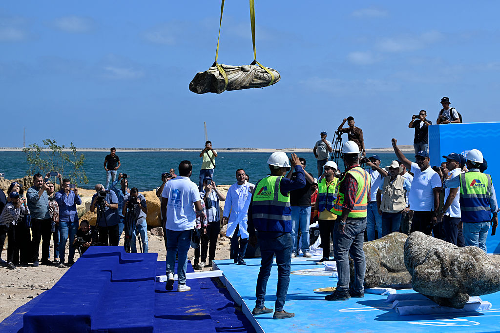 Una grúa saca un artefacto de las aguas de la bahía de Abu Qir, en Alejandría, el 21 de agosto de 2025, como parte de un evento organizado por el Ministerio de Turismo y Antigüedades para recuperar antigüedades hundidas. (KHALED DESOUKI/AFP vía Getty Images)
