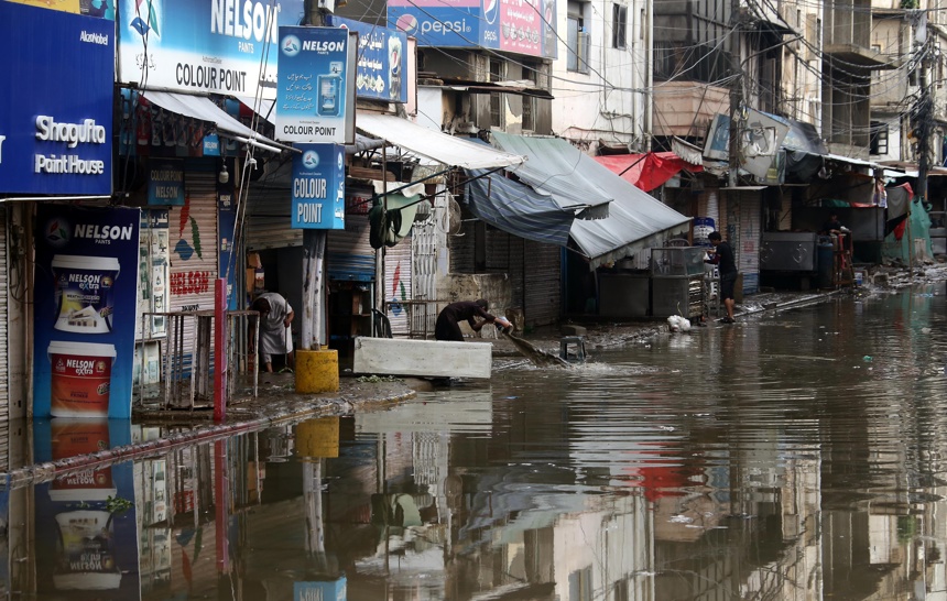 La gente retira el agua de un edificio inundado por las fuertes lluvias en Karachi, Pakistán. La Autoridad Nacional de Gestión de Desastres (NDMA) informó de que otras 978 personas han resultado heridas.(EFE/EPA/REHAN KHAN)
