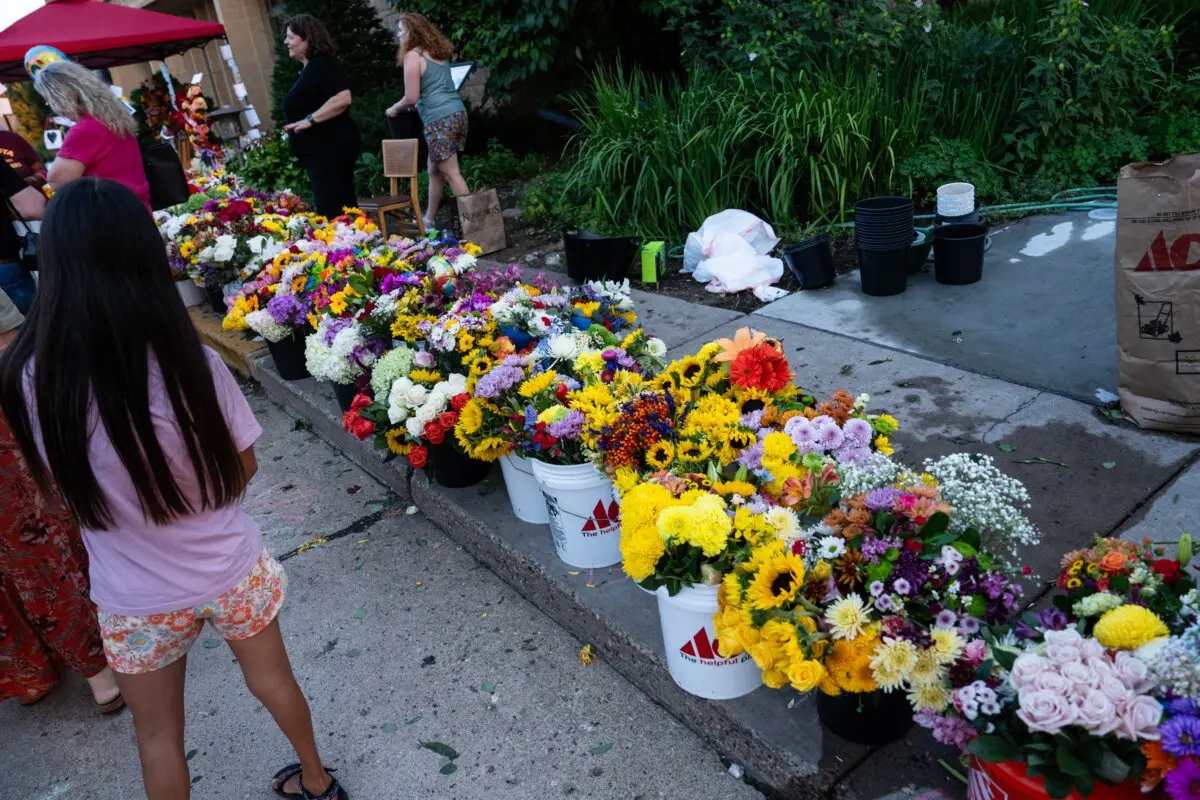 La gente deja flores mientras llora la pérdida tras el tiroteo en la escuela católica Annunciation en Minneapolis el 28 de agosto de 2025. (Madalina Kilroy/The Epoch Times)