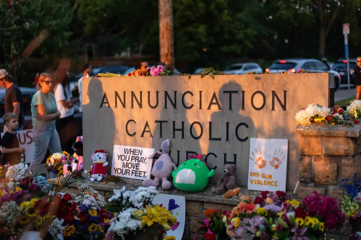 La gente deja flores en señal de duelo tras el tiroteo en la escuela católica Annunciation de Minneapolis el 28 de agosto de 2025. (Madalina Kilroy/The Epoch Times)