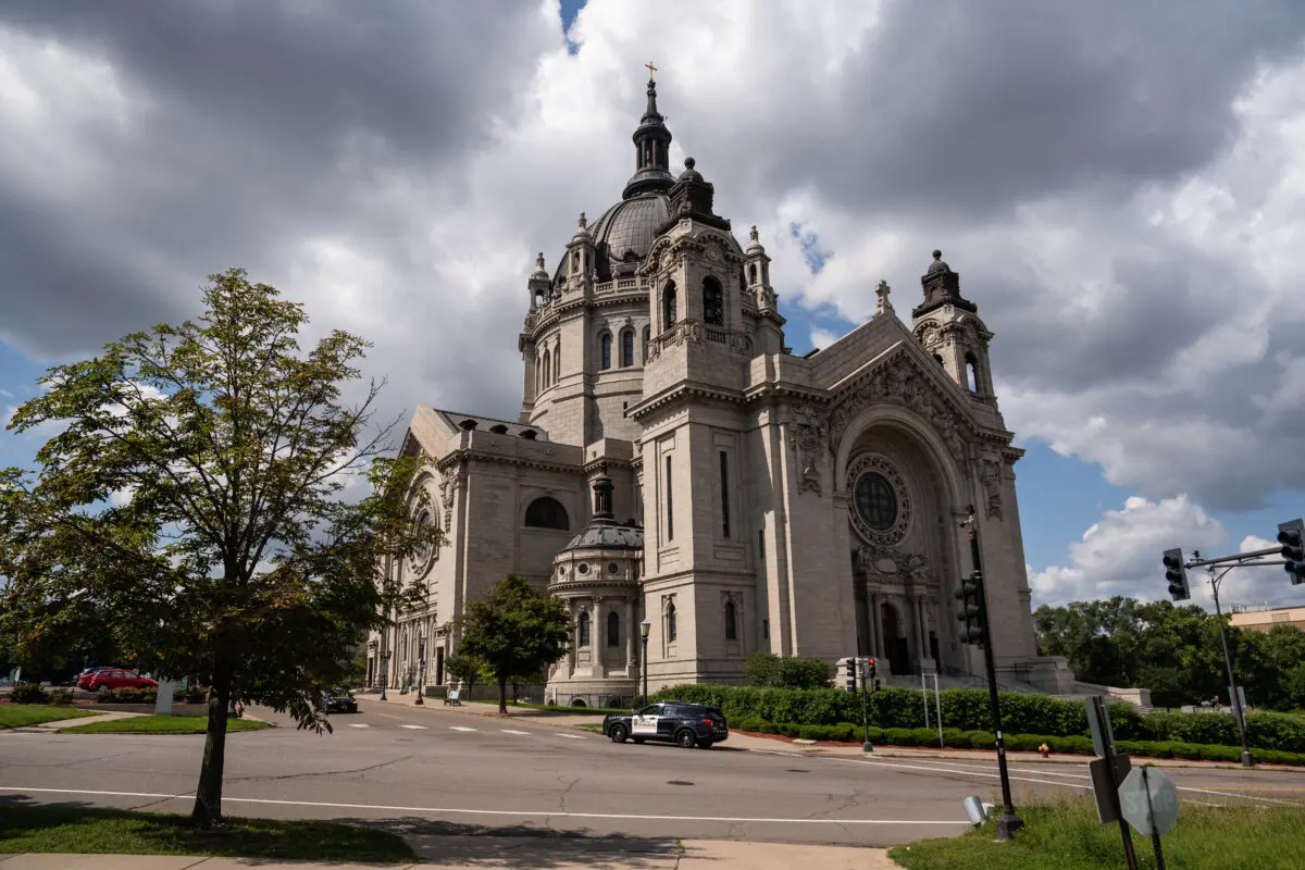 Tras un tiroteo mortal en la iglesia católica Annunciation, en las cercanías de Minneapolis, un coche de policía pasa por delante de la catedral de Saint Paul, en Saint Paul, Minnesota, el 28 de agosto de 2025. (Madalina Kilroy/The Epoch Times)