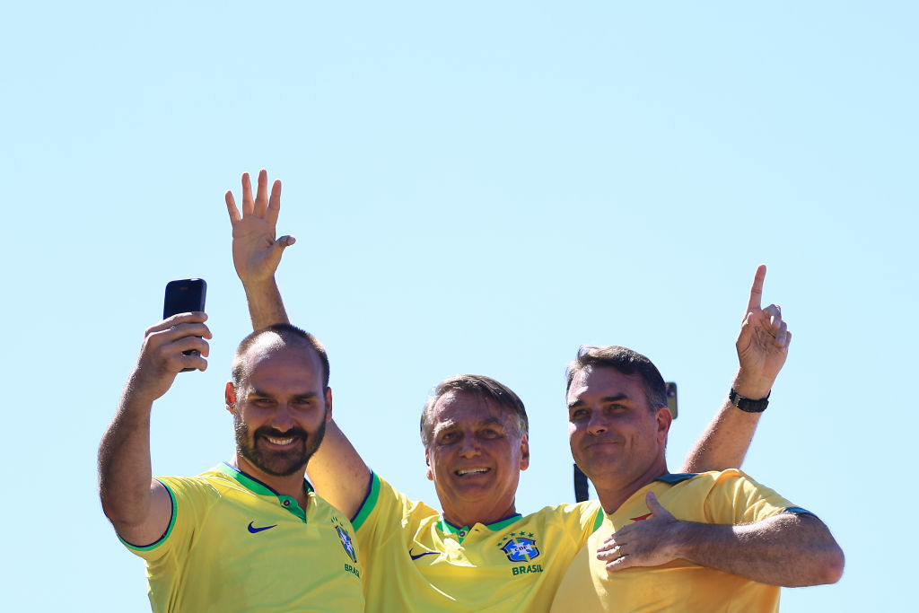 El expresidente brasileño Jair Bolsonaro, acompañado por sus hijos Eduardo Bolsonaro (izq.) y Flavio Bolsonaro, saluda a sus simpatizantes durante un mitin en la playa de Copacabana el 21 de abril de 2024 en Río de Janeiro, Brasil. (Foto de Buda Mendes/Getty Images)