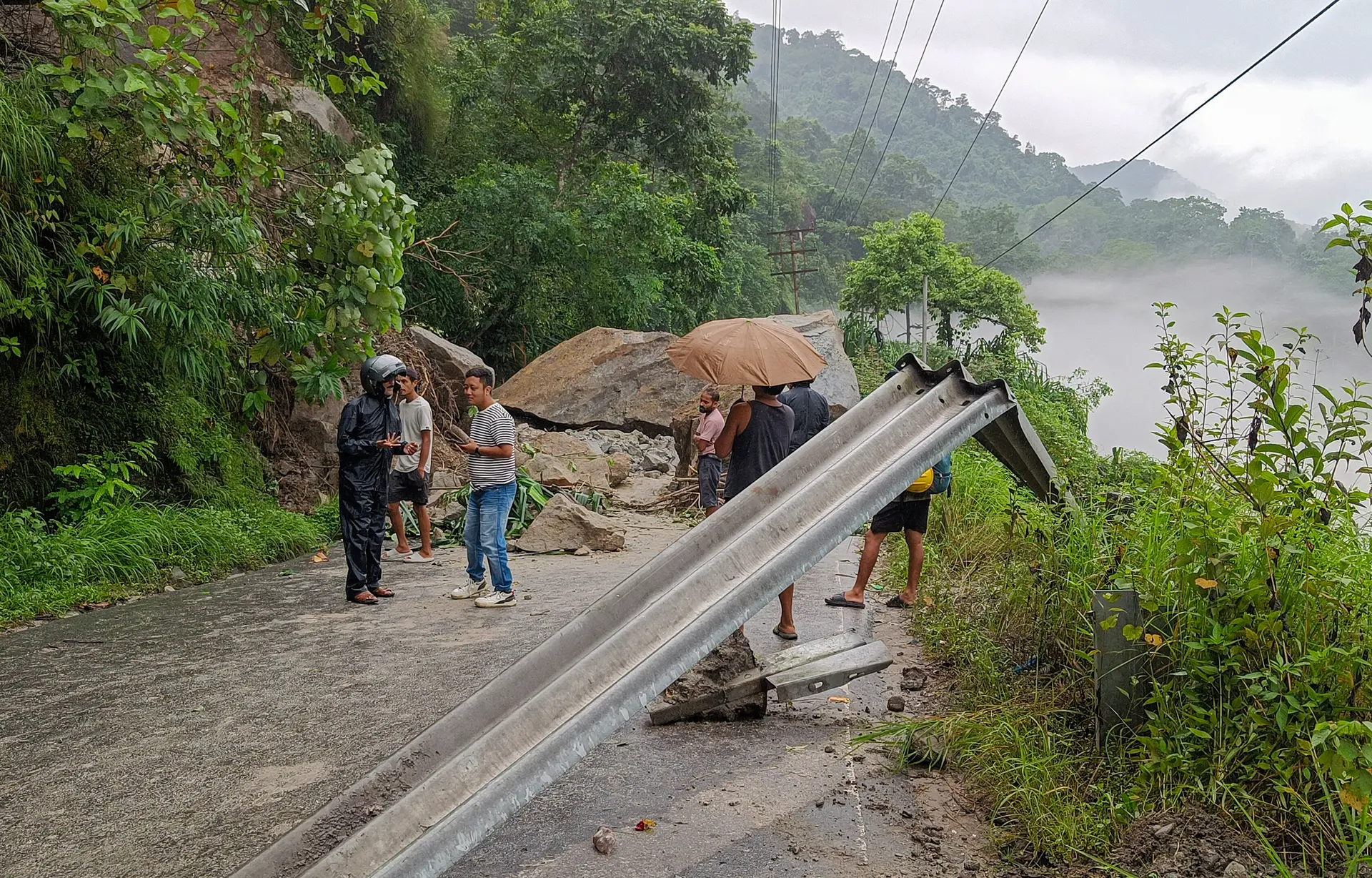 Aldeanos y turistas indios cerca de los escombros después de que un deslizamiento de tierra bloqueara la Carretera Nacional 10 en la zona de Kalijhora, cerca de Sevok, a 27 kilómetros de Siliguri, India, el 30 de agosto de 2025. (Diptendu Dutta/Middle East Images/AFP vía Getty Images.)