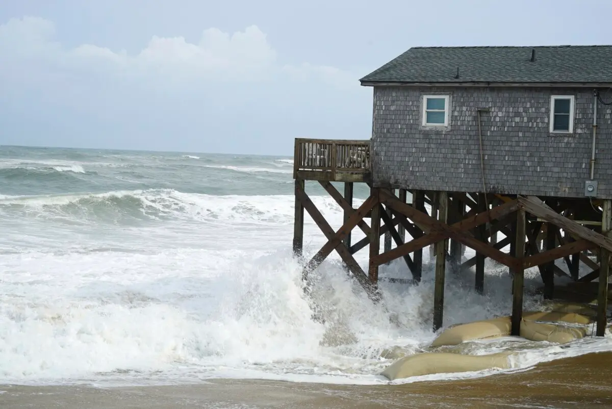 <em>Las olas del huracán Erin rompen contra los pilotes protegidos con sacos de arena de un edificio en Buxton, Carolina del Norte, el 20 de agosto de 2025. Allen G. Breed/AP Photo</em>