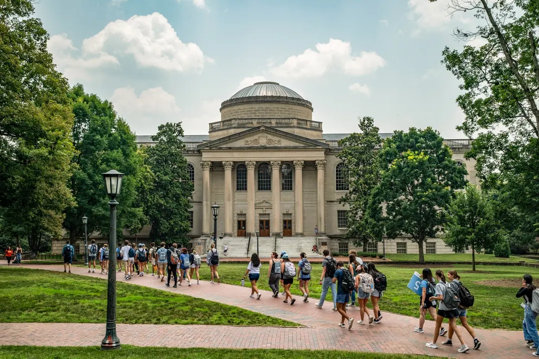Un grupo de personas camina por el campus de la Universidad de Carolina del Norte en Chapel Hill, Carolina del Norte, el 29 de junio de 2023. En la escuela insignia del estado, el tope para estudiantes de fuera del estado, que incluye a otros ciudadanos estadounidenses, inmigrantes ilegales y estudiantes internacionales, es del 18%. (Eros Hoagland/Getty Images)