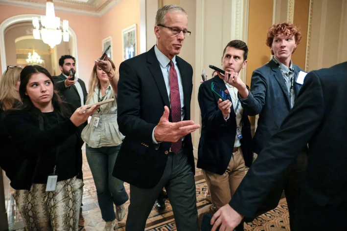 Los periodistas rodean al líder de la mayoría del Senado, John Thune (R-S.D.), mientras se desplaza entre su oficina y la Cámara del Senado en el Capitolio de Estados Unidos, el 1 de agosto de 2025. (Chip Somodevilla/Getty Images)