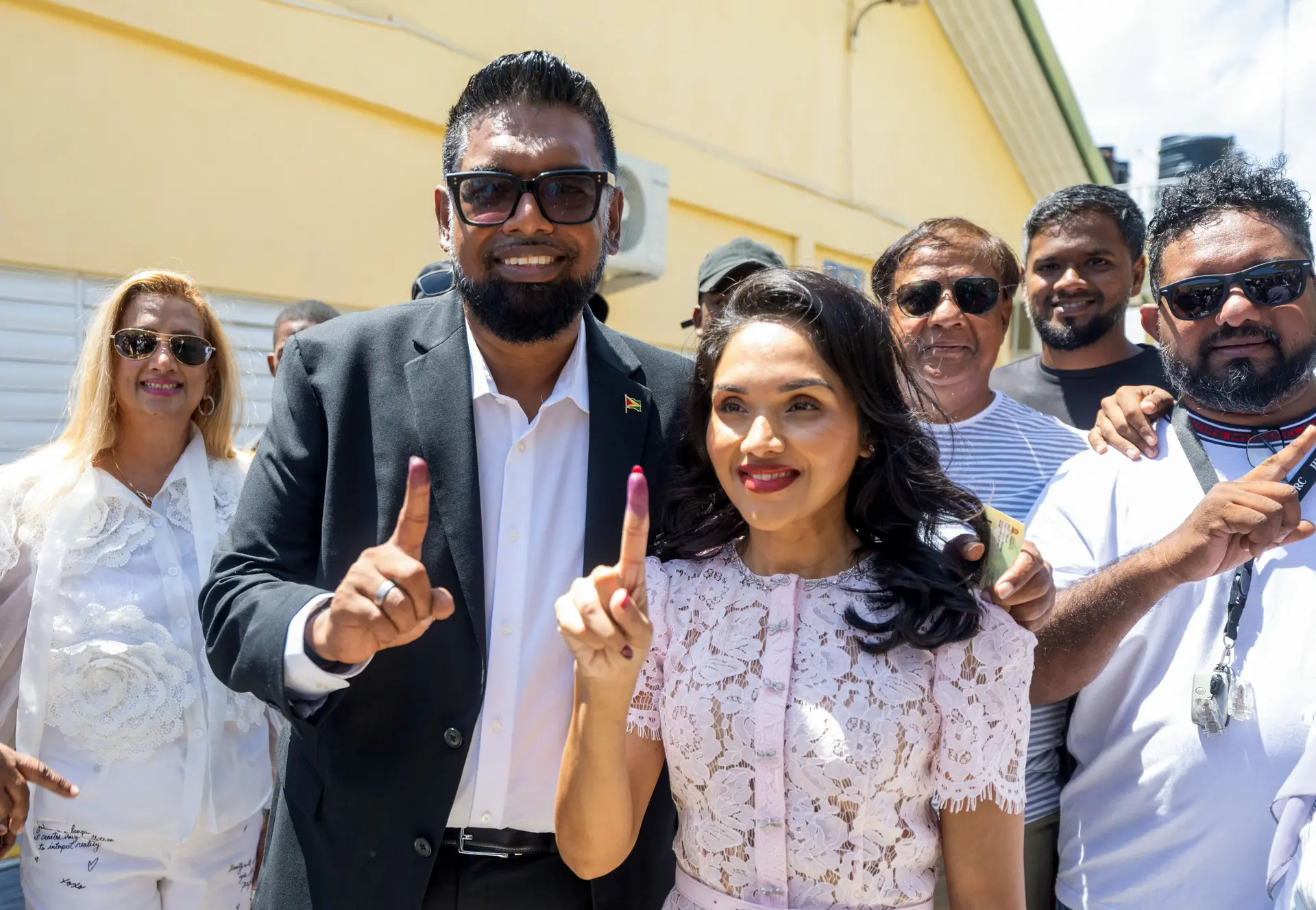 El presidente de Guyana y candidato a la reelección, Mohamed Irfaan Ali, y su esposa Arya hacen un gesto a los medios tras votar en un colegio electoral durante las elecciones presidenciales en Leonora, Guyana, el 1 de septiembre de 2025. (Keno George/AFP vía Getty Images)