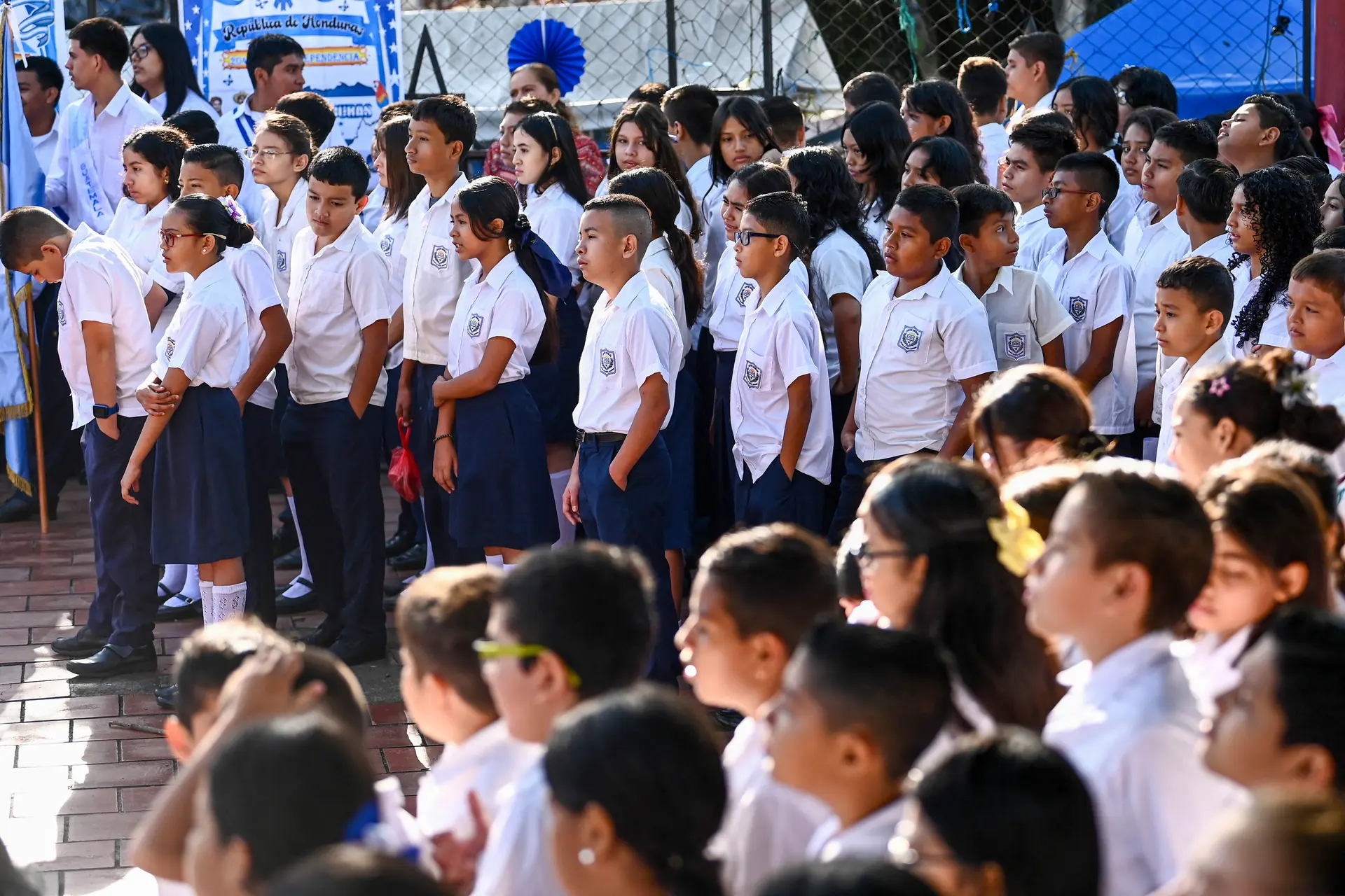 Estudiantes asisten a un evento que da inicio a las festividades cívicas en El Salvador, en la escuela Las Brisas, San Salvador, El Salvador, el 1 de septiembre de 2025. Desde el 20 de agosto, por orden de la nueva Ministra de Educación, la Capitana Karla Trigueros, los estudiantes deben seguir nuevas normas disciplinarias: cabello corto, uniformes limpios y zapatos lustrados. Mientras que un sindicato de maestros calificó estas normas como la "militarización" de las 5100 escuelas públicas, el presidente salvadoreño Nayib Bukele las defendió, afirmando que buscan evitar que las escuelas se conviertan en "centros de reclutamiento de pandillas". (Marvin Recinos/AFP vía Getty Images)
