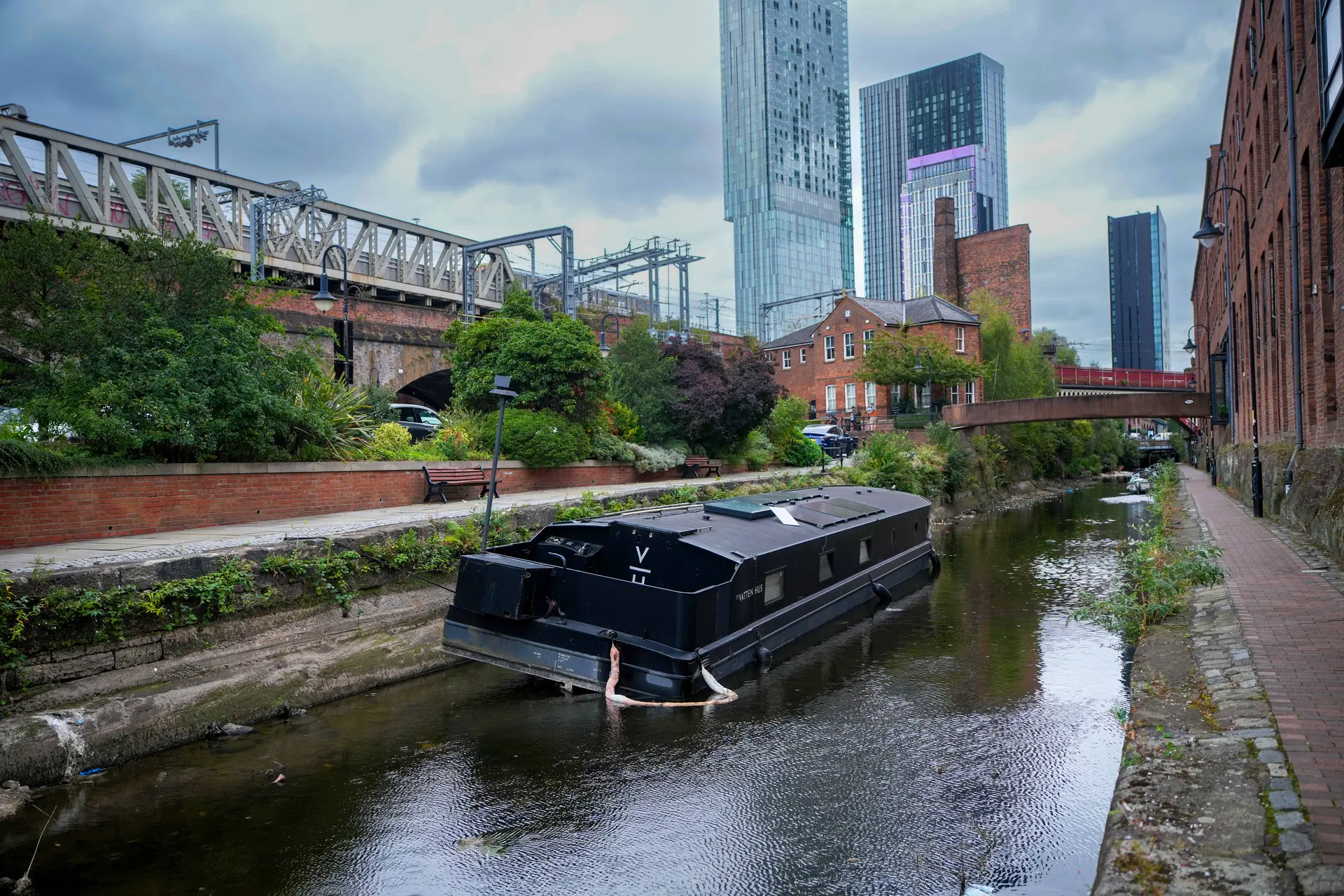 Una barcaza se encuentra en el fondo de una sección parcialmente seca del Canal de Rochdale, en el centro de Mánchester, Inglaterra, el 1 de septiembre de 2025. Si bien se han recibido informes de vaciado deliberado de canales que se investigan como vandalismo, la primavera históricamente seca de este año y las condiciones de sequía prolongada han dificultado principalmente la gestión de los niveles de agua del canal, según Canal & River Trust. (Christopher Furlong/Getty Images)