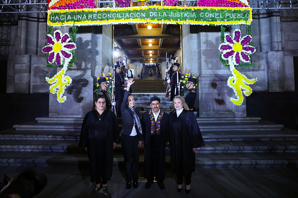 <em>La presidente de México, Claudia Sheinbaum, saluda junto a la ministra Lenia Batres Guadarrama (izquierda), el presidente de la Corte Suprema, Hugo Aguilar Ortiz, y la ministra Yasmin Esquivel Moss (derecha) durante la ceremonia de toma de posesión de los nuevos ministros de la Corte Suprema de México en el edificio de la Corte Suprema, el 1 de septiembre de 2025, en la Ciudad de México, México. (Héctor Vivas/Getty Images)</em>