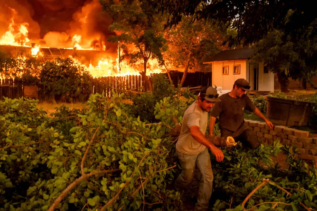 Layne Smith (izquierda) despeja la vegetación para evitar que las llamas se propaguen a su casa mientras el incendio 6-5 arrasa la comunidad de Chinese Camp en el condado de Tuolumne, California, el 2 de septiembre de 2025. (Noah Berger/AP Photo)