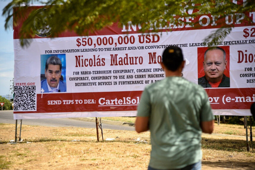 Un hombre observa una pancarta en la que se ofrece una recompensa por información que conduzca al arresto del presidente venezolano Nicolás Maduro y del ministro de Relaciones Interiores, Justicia y Paz de Venezuela, Diosdado Cabello, en Villa del Rosario, Colombia, el 23 de agosto de 2025. (Schneyder Mendoza/AFP vía Getty Images).