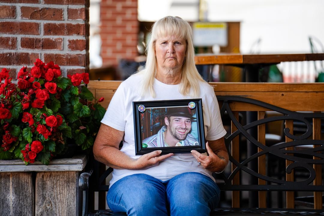 Mary Bell sostiene una foto de su hijo Joshua Shelton, que murió por intoxicación con fentanilo a los 39 años, en Norton, Virginia, el 15 de agosto de 2025. (Samira Bouaou/The Epoch Times)