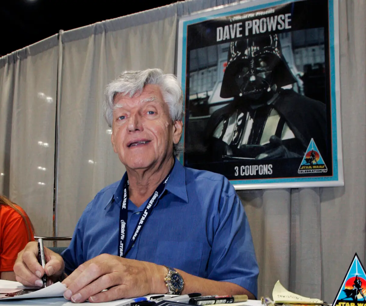 El actor David Prowse, que interpretó a Darth Vader con el traje negro en la primera película de Star Wars, firma autógrafos el 26 de mayo de 2007 en la Star Wars Celebration IV en Los Ángeles, con motivo del 30.º aniversario del estreno de la primera película de la saga Star Wars. (Reed Saxon/AP Photo)