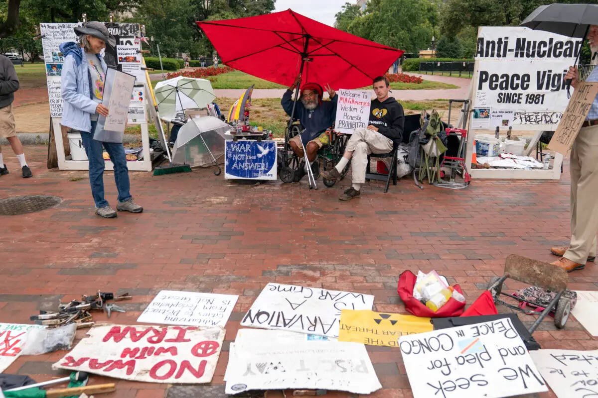 Philipos Melaku-Bello (centro izq.) y Will Rosin (centro der.) hacen el signo de la victoria durante la Vigilia por la Paz en el parque Lafayette, frente a la Casa Blanca, en Washington, el 7 de septiembre de 2025. (José Luis Magana/AP Photo)