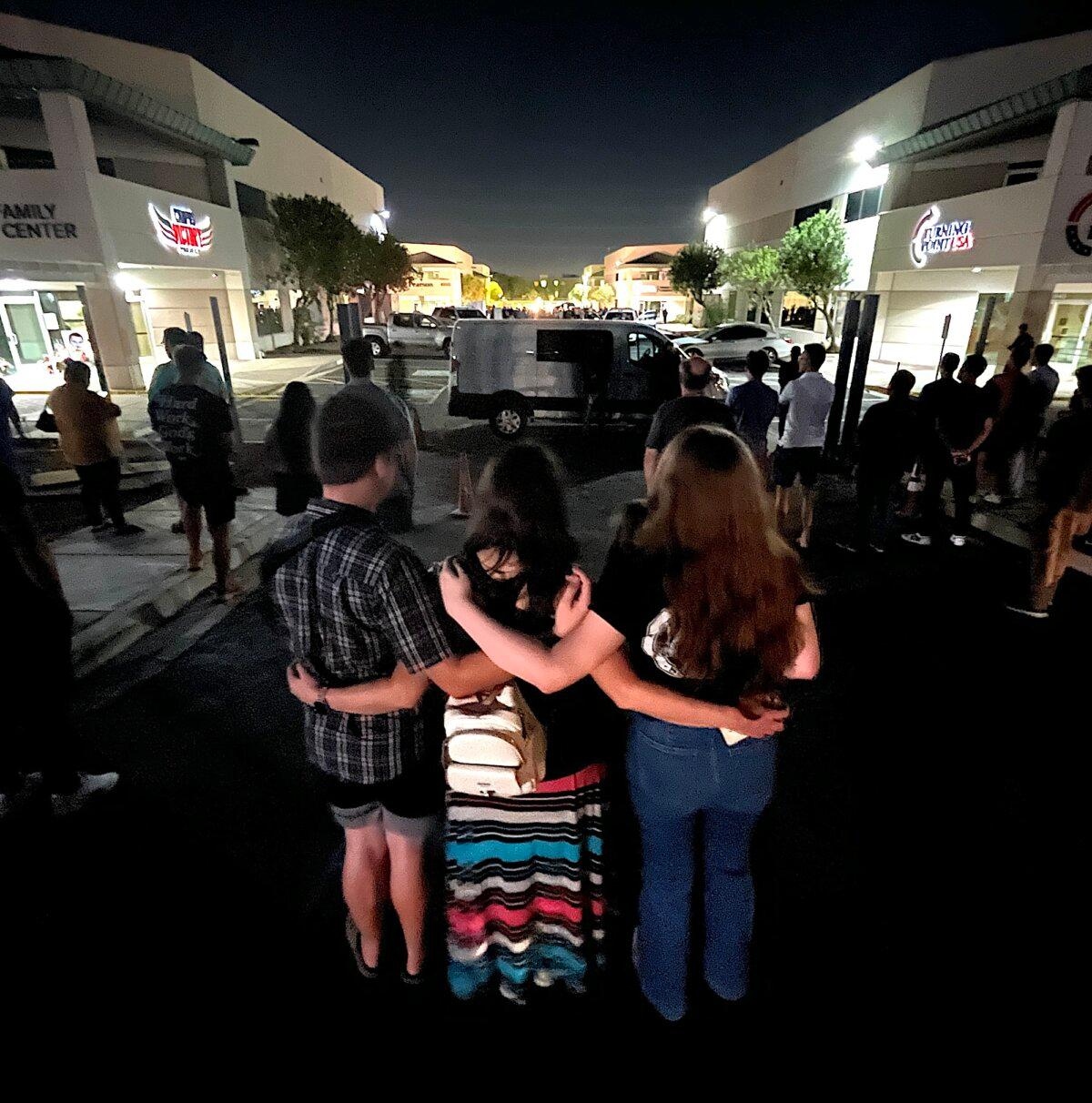 Tres seguidores del activista conservador asesinado Charlie Kirk se abrazan fuera de una ceremonia privada para el personal de Turning Point USA en Phoenix, Arizona, el 10 de septiembre de 2025. (Allan Stein/The Epoch Times)
