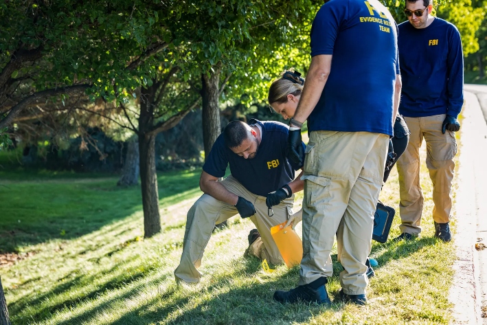 Agentes de las fuerzas del orden, incluidos miembros de un equipo forense del FBI, investigan cerca de la escena del crimen donde Charlie Kirk fue asesinado a tiros en la Universidad del Valle de Utah, en Orem, Utah, el 11 de septiembre de 2025. (Melissa Majchrzak/AFP a través de Getty Images)