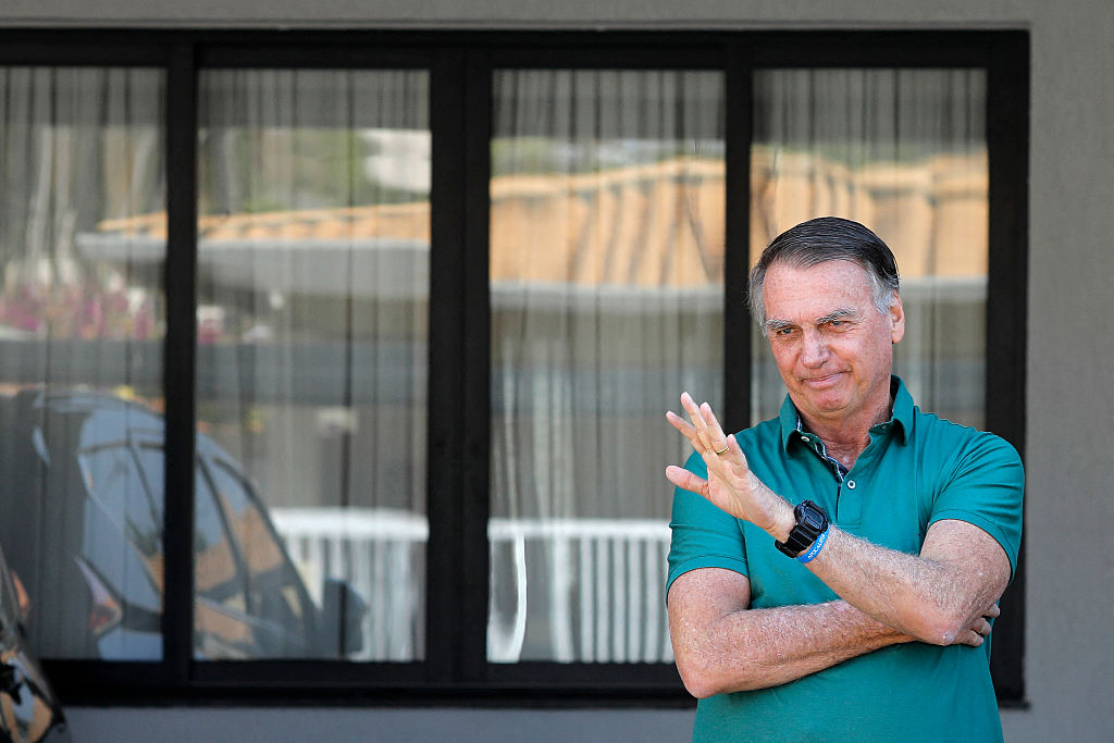 El expresidente brasileño Jair Bolsonaro saluda desde su residencia en Brasilia el 11 de septiembre de 2025, un día después que un juez brasileño emitió el primer voto de inocencia en el juicio por conspiración golpista en su contra.  (Foto de SERGIO LIMA/AFP vía Getty Images)